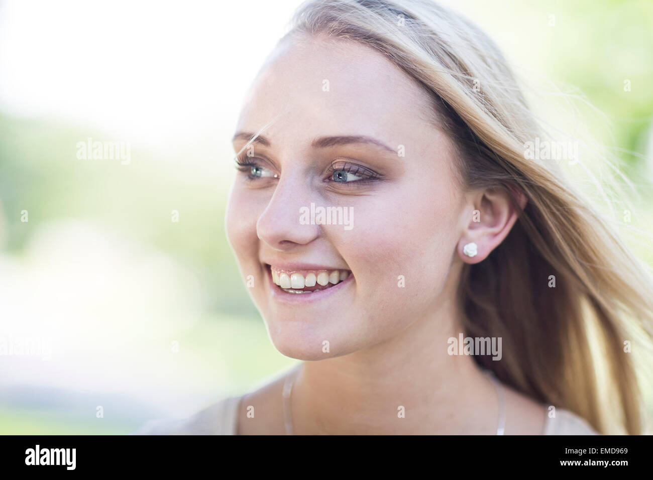 Portrait of smiling blond young woman outdoors Stock Photo - Alamy