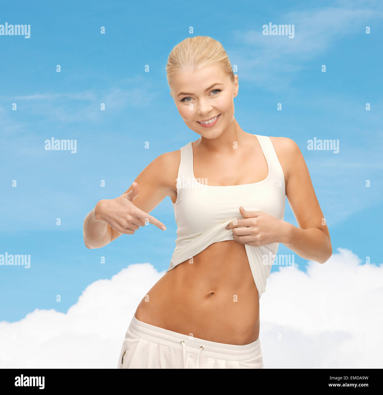 beautiful sporty woman pointing at her abs Stock Photo - Alamy