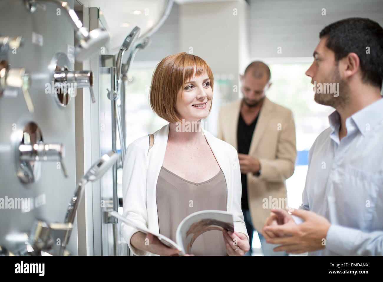 Female customer asking bathroom shop salesman about products Stock ...