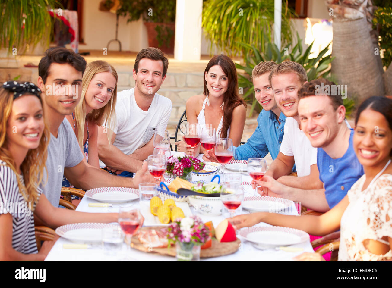 Large Group Of Young Friends Enjoying Outdoor Meal Together Stock Photo