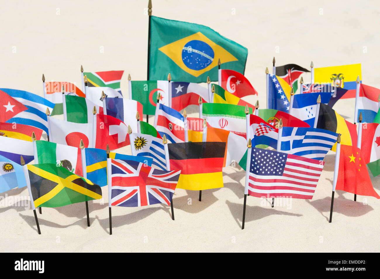 Brazilian flag surrounded by international flags flying on smooth sand