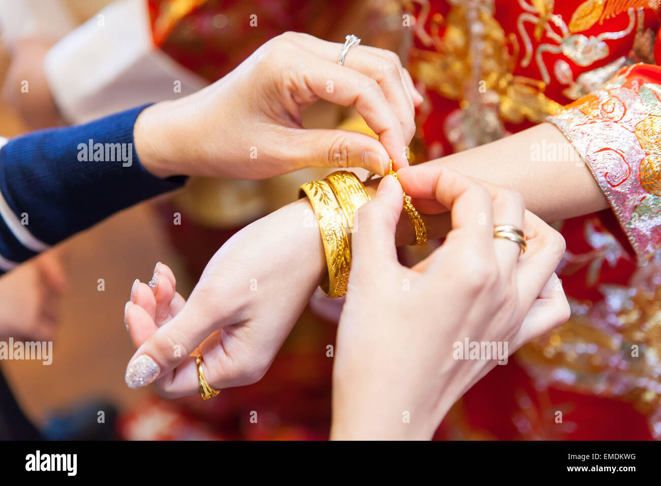 Elderly relatives presenting the golden bracelet as a blessing in chinese wedding Stock Photo