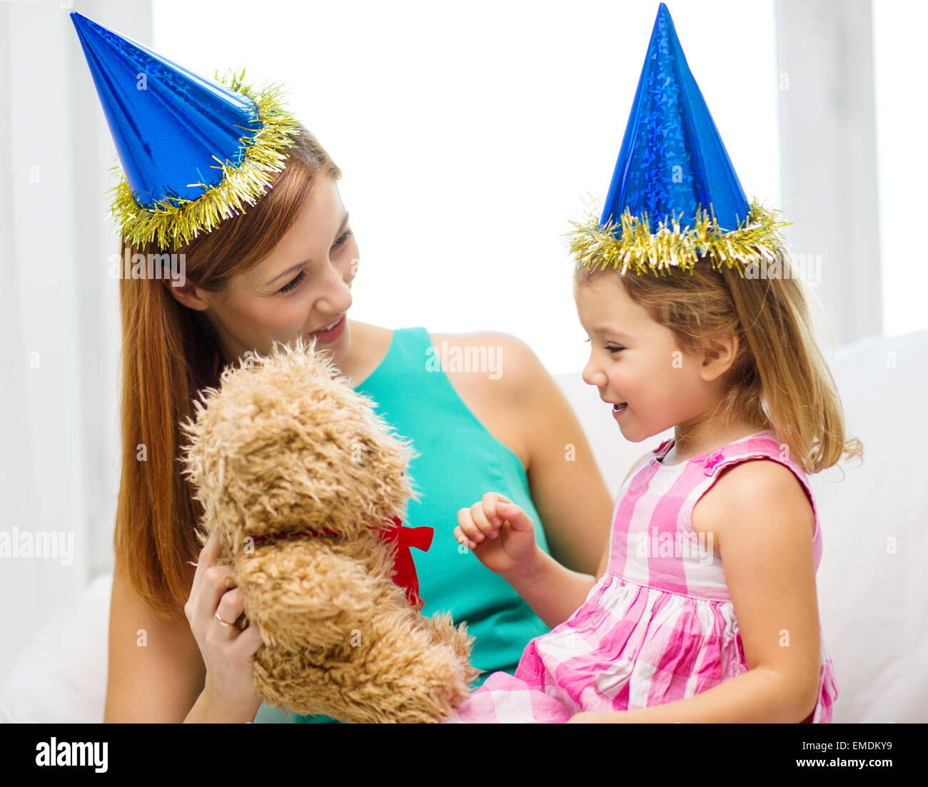 mother and daughter in blue hats with teddy bear Stock Photo - Alamy