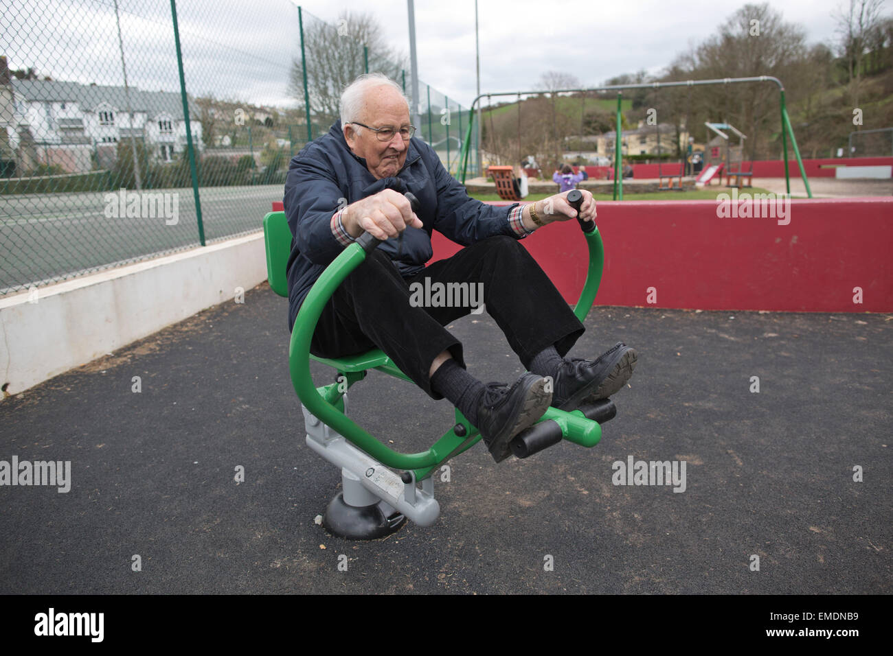 Elderly couple in their late 70's (her) and early 80's (him) exercising on outdoor fitness equipment, Kingsbridge, Devon, UK Stock Photo