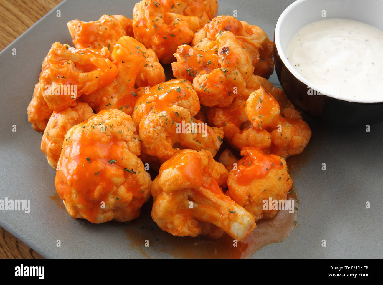 buffalo style cauliflower appetizer with ranch dipping sauce on a plate