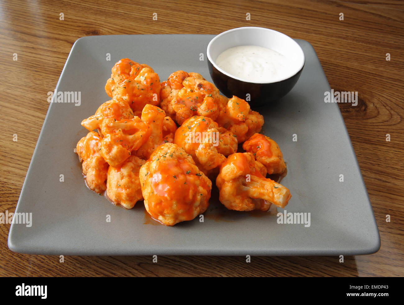 buffalo-style cauliflower piled up on a plate with ranch dipping sauce Stock Photo
