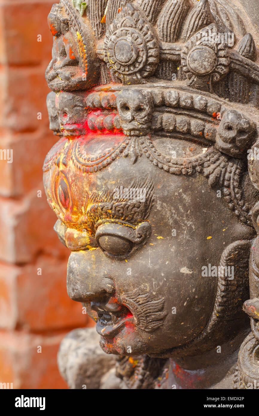 Statue of the wrathful deity Mahakala marked with colored powders at the religious Swayambhunath site in Kathmandu, Nepal Stock Photo