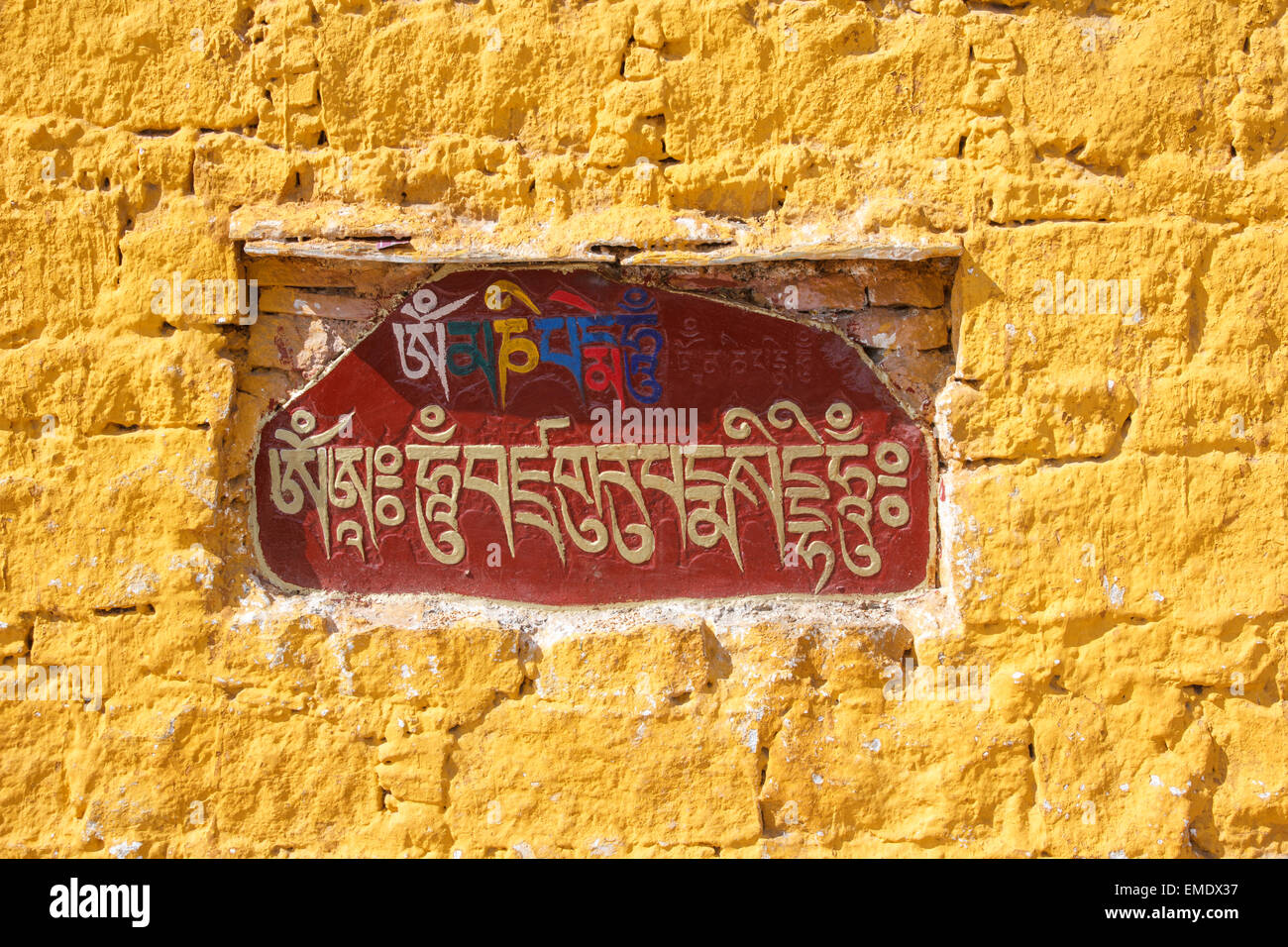 The Sanskrit mantra 'Om mani padme hum' inscribed and painted on a mani stone embedded in a wall of the Potala Palace in Lhasa, Stock Photo
