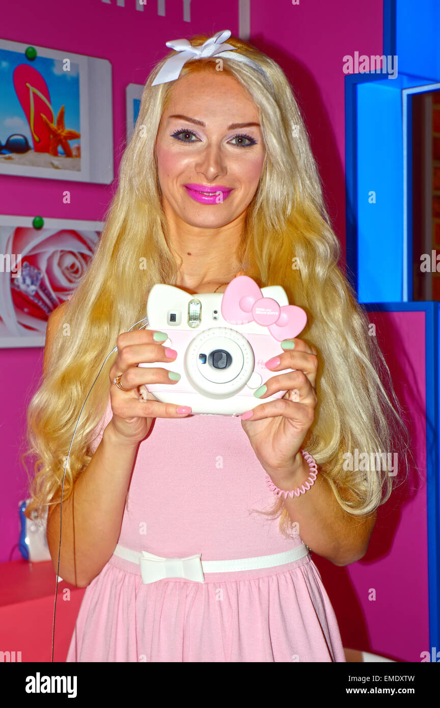 Young female model posing with a digital camera on a stand-known manufacturer of photographic equipment Photo Expo-2015. Moscow Stock Photo