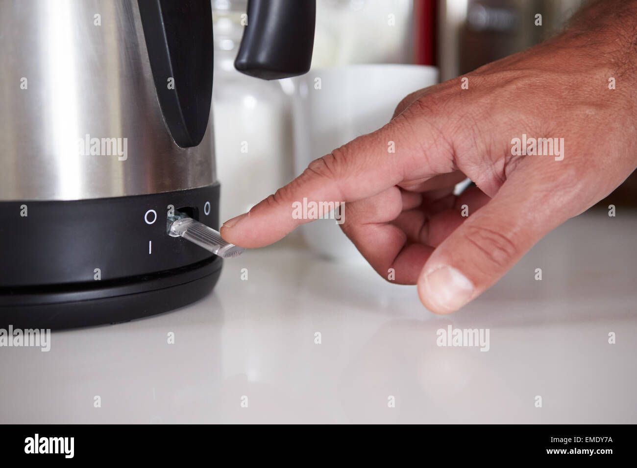 Close Up Of Man Turning On Switch To Boil Kettle Stock Photo