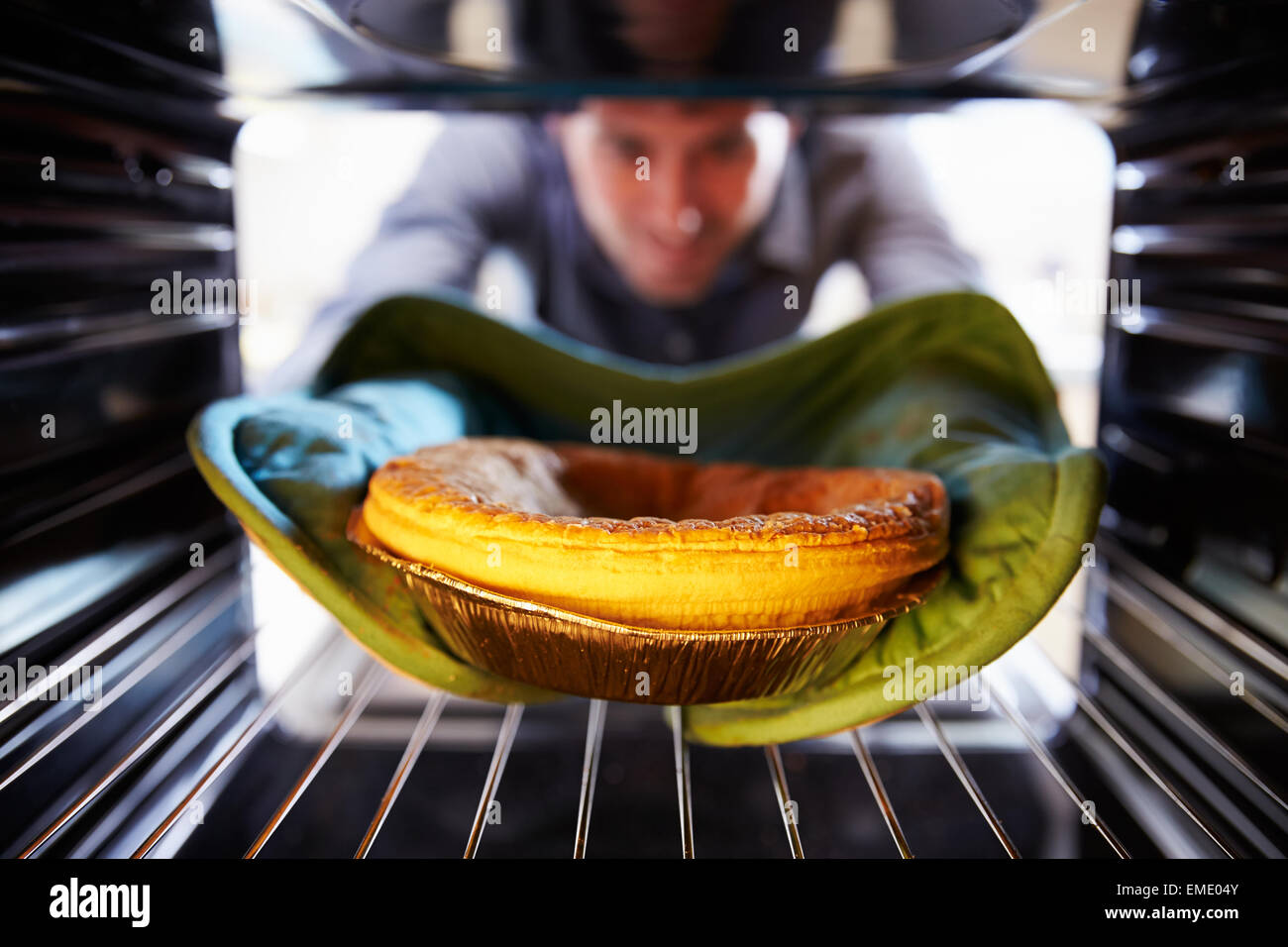 Man Putting Savoury Pie Into Oven To Bake Stock Photo Alamy