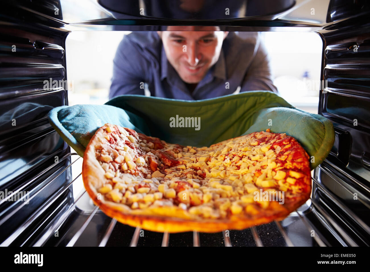 Man Putting Pepperoni Pizza Into Oven To Cook Stock Photo Alamy