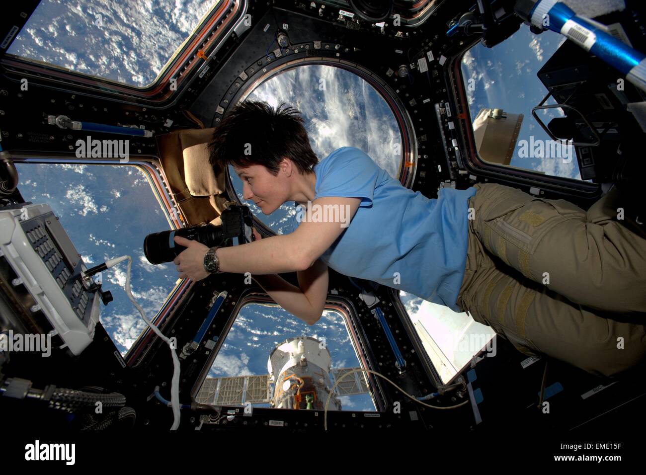International Space Station Expedition 42 European Space Agency Astronaut Samantha Cristoforetti takes photos from inside the copula look out at Earth February 3, 2015 in Earth Orbit. Stock Photo