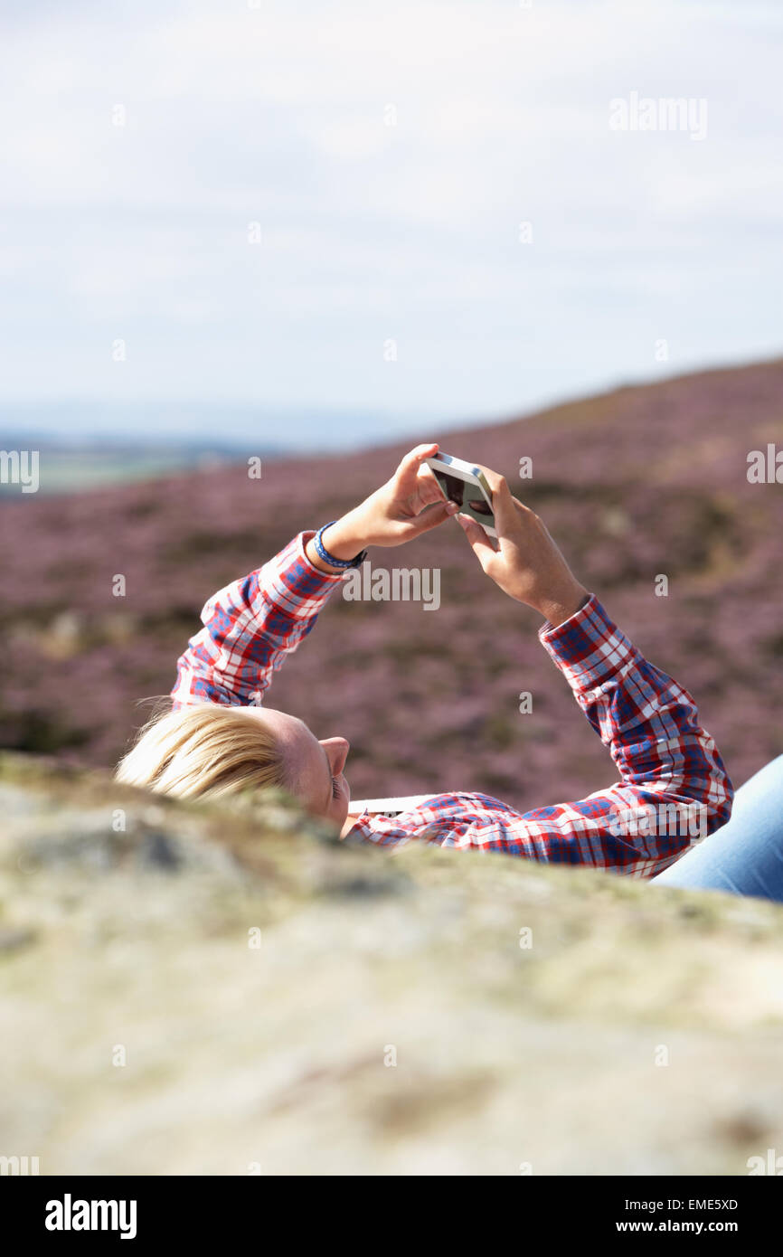 Teenage Girl Using Mobile Phone In Countryside Stock Photo