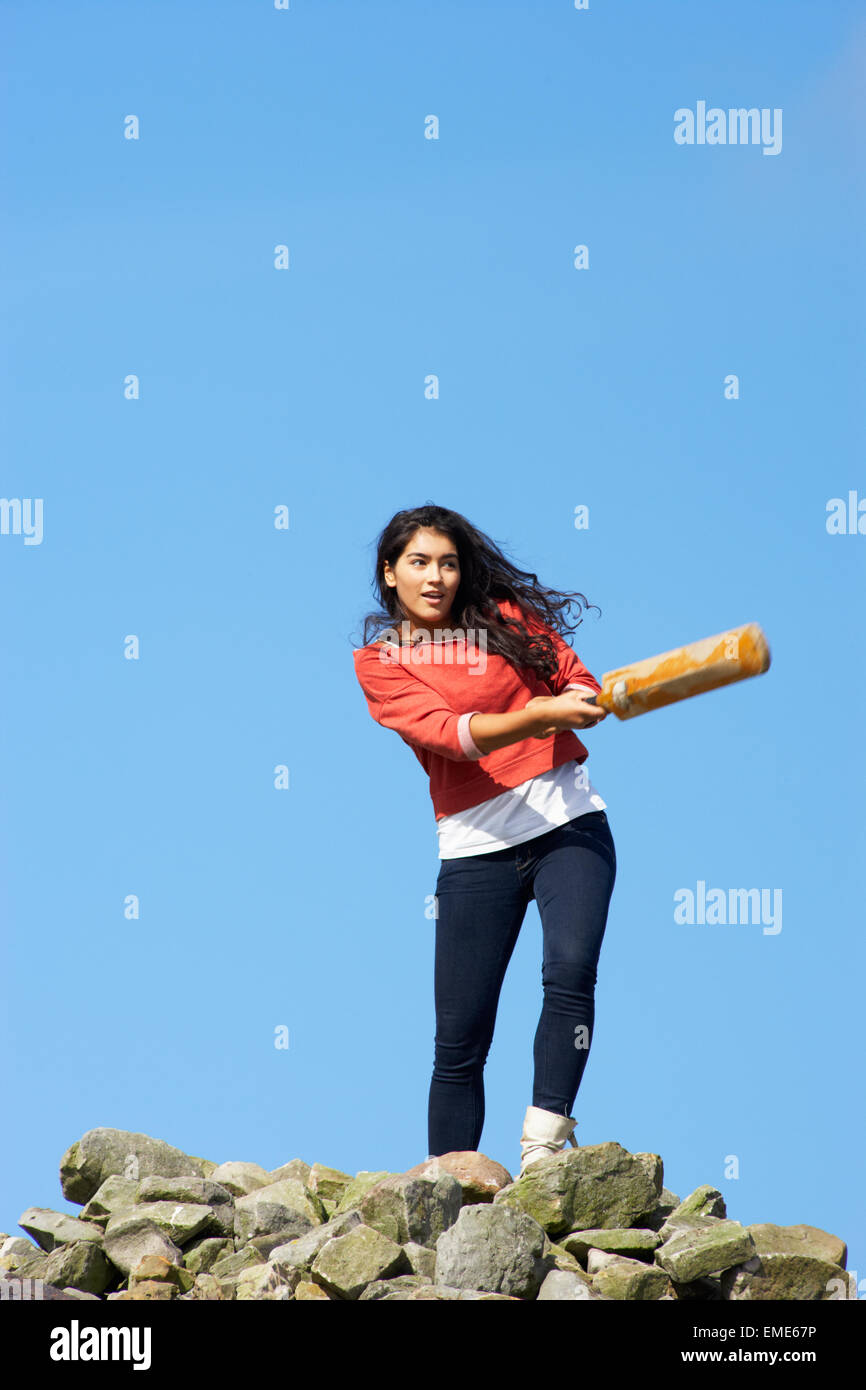 Teenage Girl Playing Cricket Outdoors Stock Photo