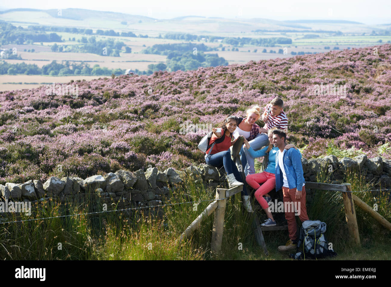 Group Of Young People Hiking Through Countryside Stock Photo - Alamy
