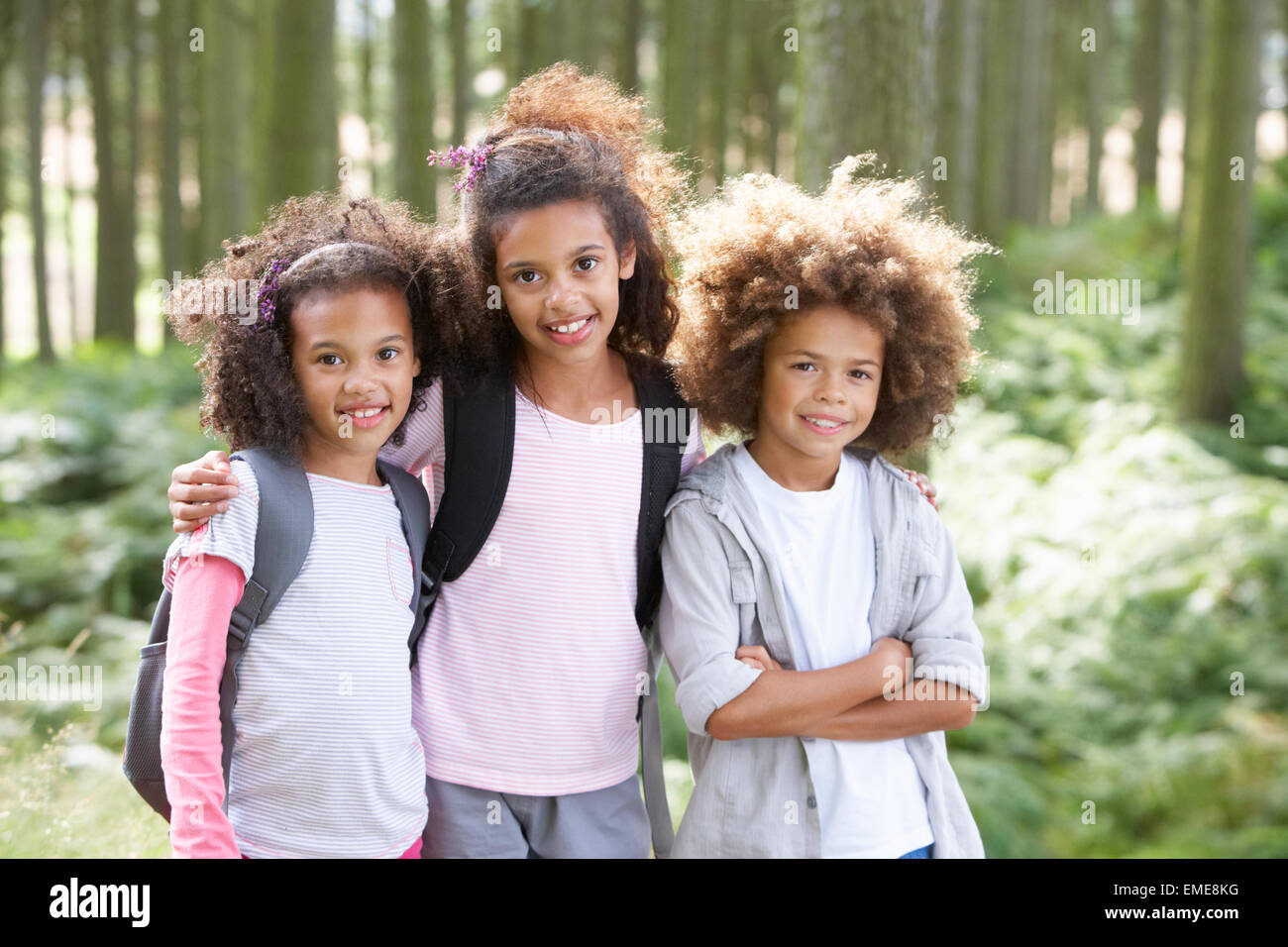 Three Children Exploring Woods Together Stock Photo