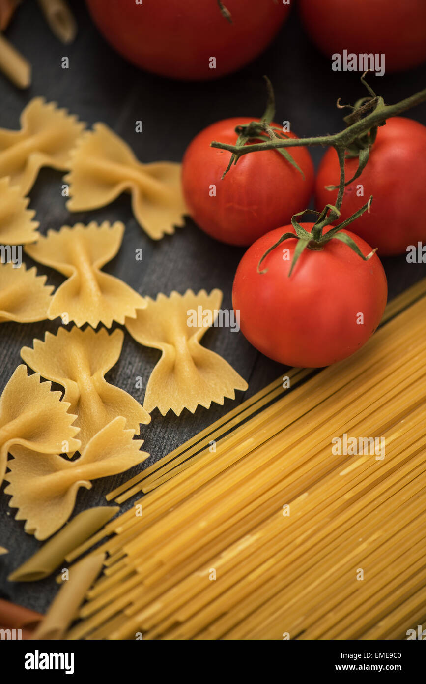 food background on rustic wood with pasta and tomatoes Stock Photo - Alamy