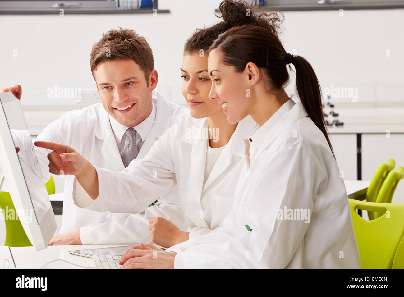 Group Of Scientists Checking Laboratory Results On Computer Stock Photo