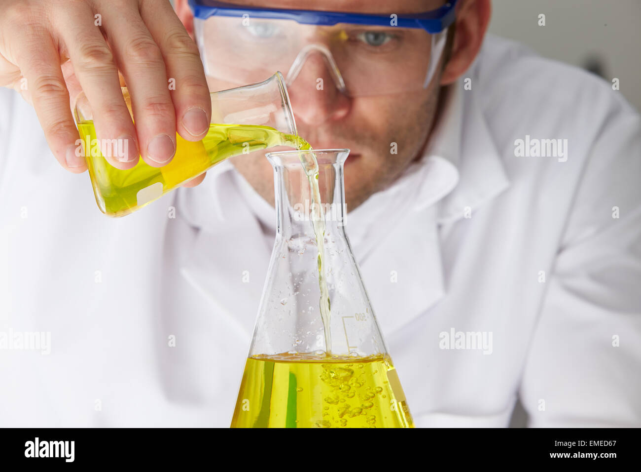 Scientist Pouring Liquid Into Flask Stock Photo