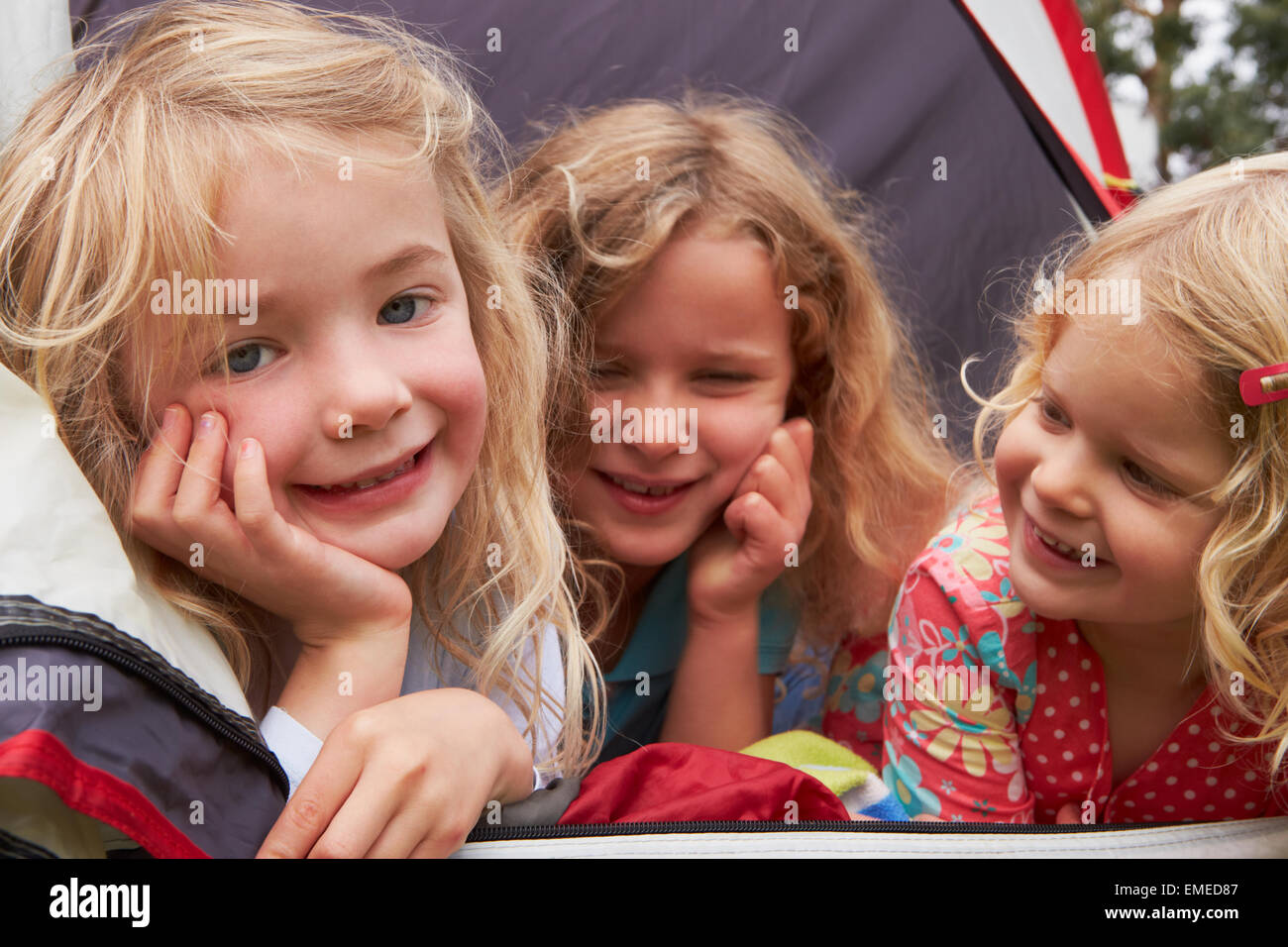 Three Girls Enjoying Camping Holiday On Campsite Stock Photo