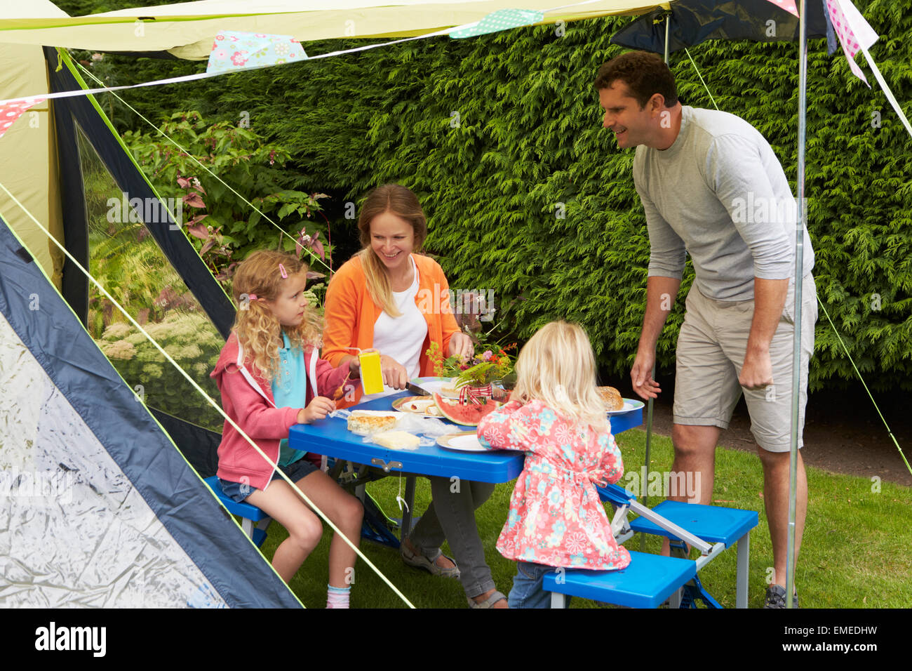 Family Enjoying Meal Outside Tent On Camping Holiday Stock Photo