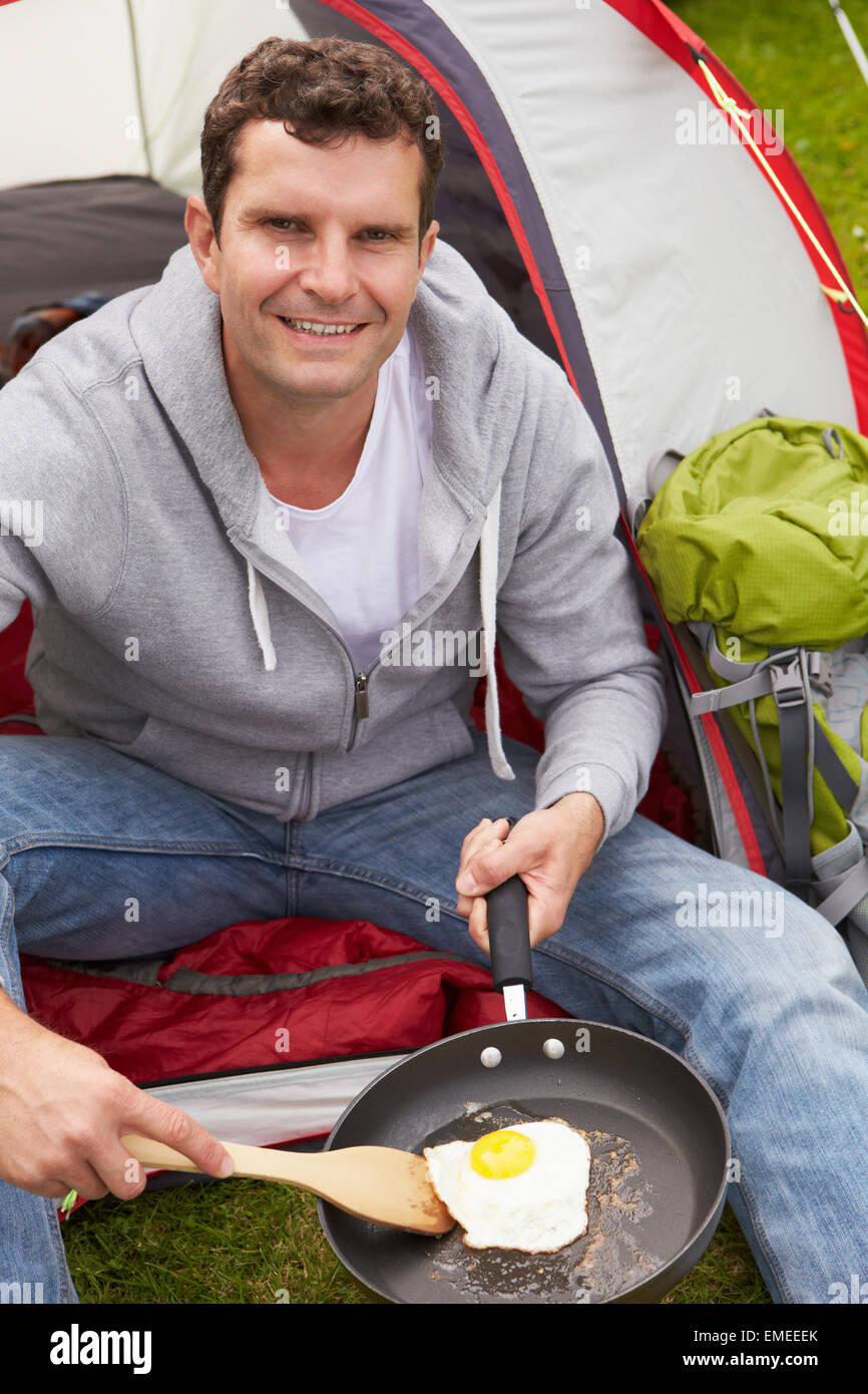 Man On Camping Holiday Frying Egg In Pan Stock Photo