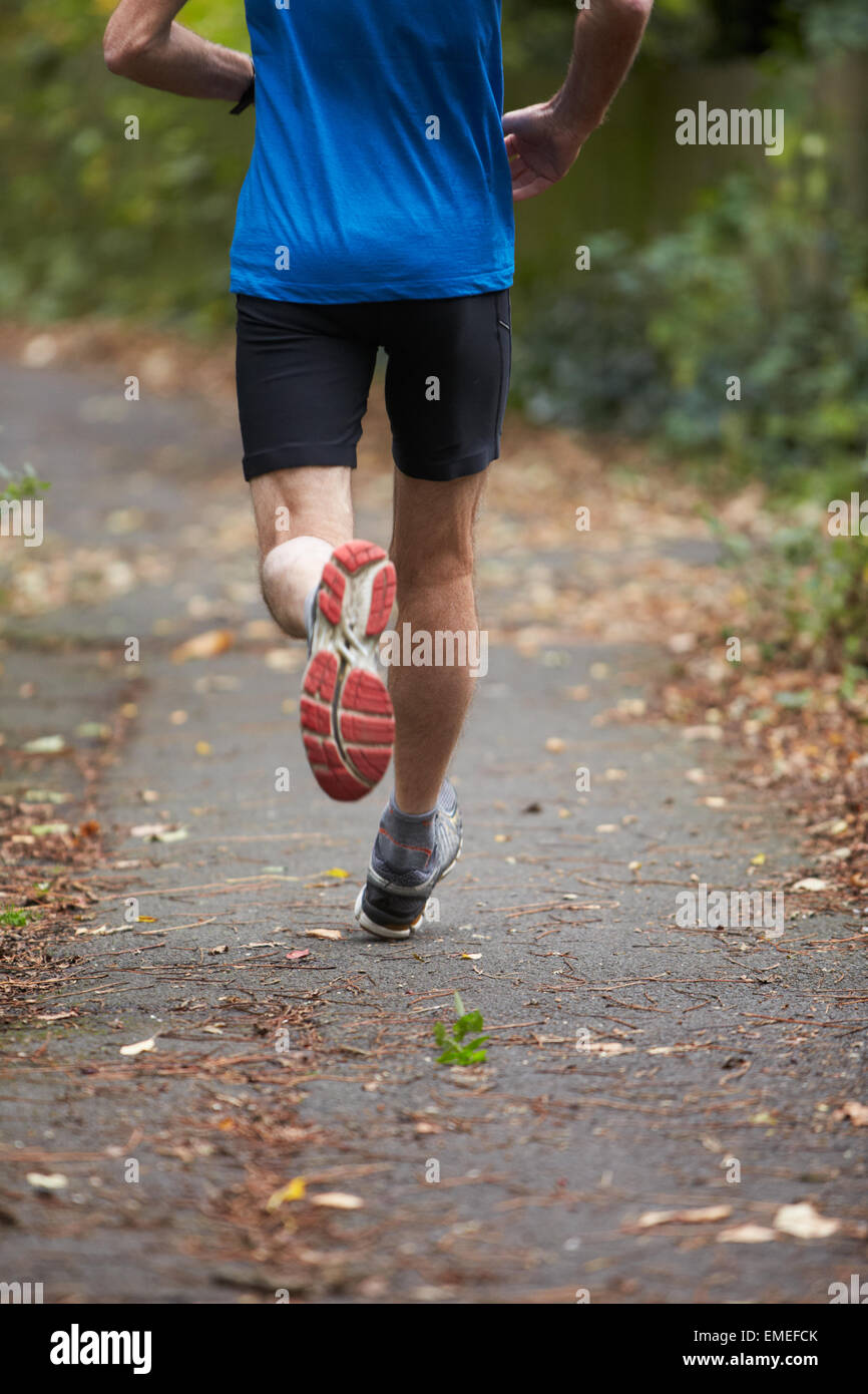 Close Up Of Jogger's Feet Running On Path Stock Photo