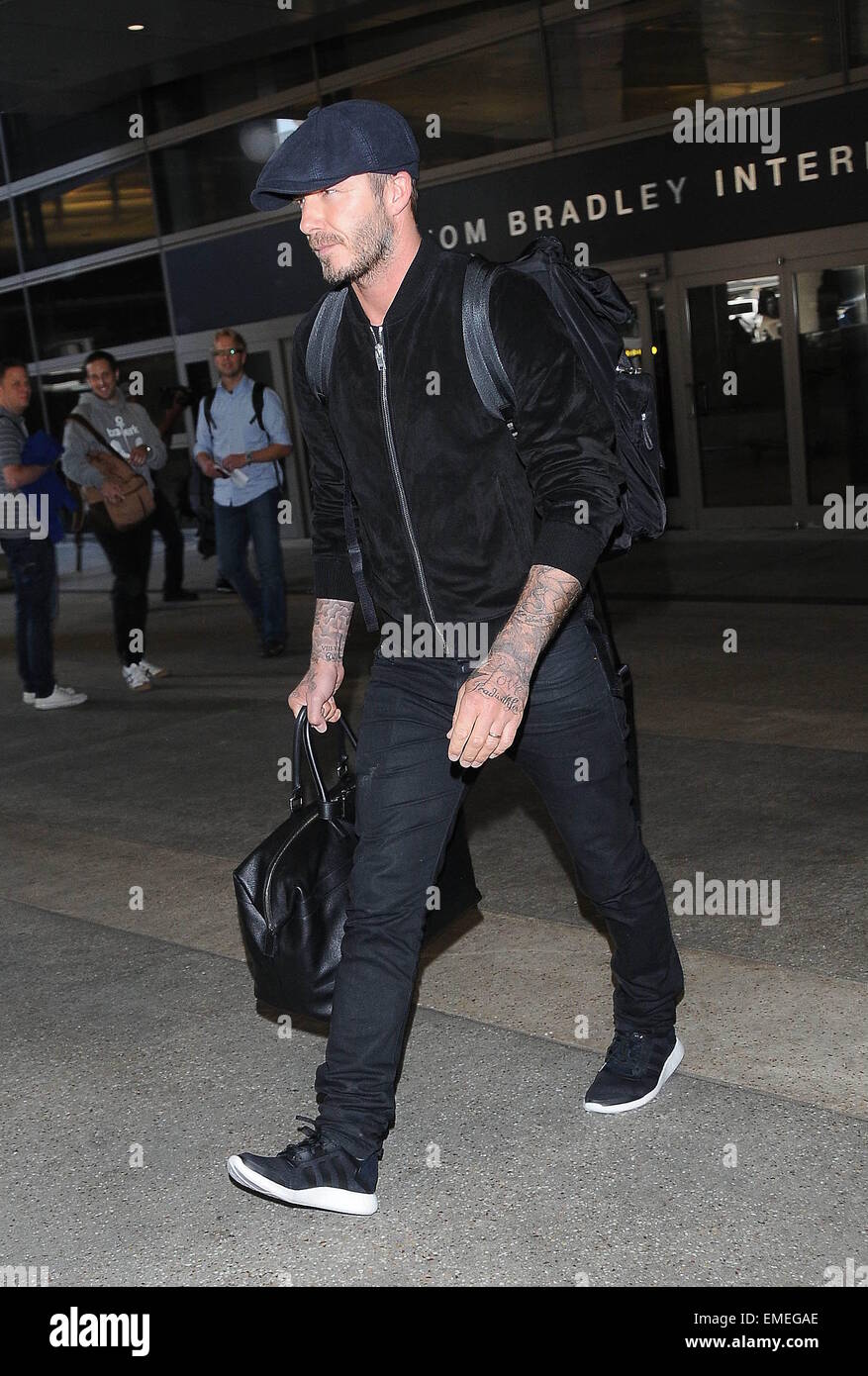 David Beckham arrives at Los Angeles International Airport wearing a flat cap, black bomber jacket and carrying luggage  Featuring: David Beckham Where: Los Angeles, California, United States When: 16 Oct 2014 Stock Photo