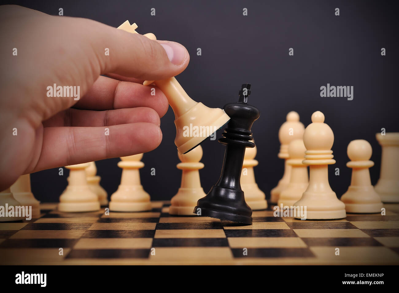 White Chess King makes a checkmate Black King on chessboard Stock Photo -  Alamy