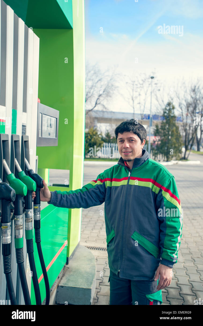 Smiling worker at the gas station, while filling a car Stock Photo