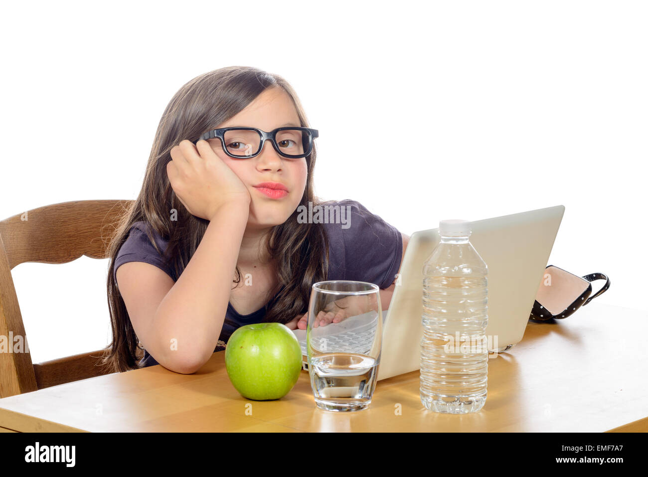 a tired little girl with her computer and an apple Stock Photo