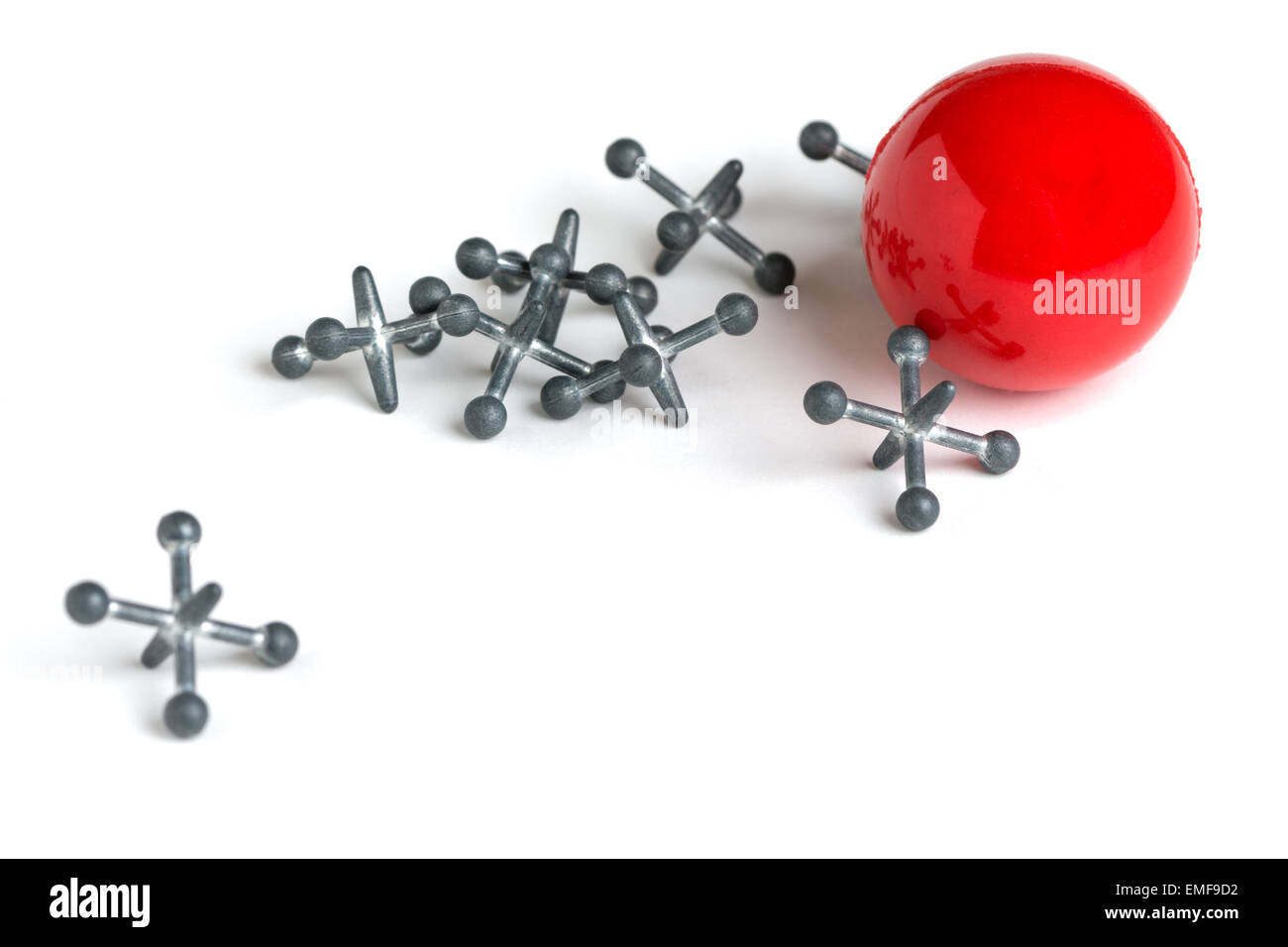 A set of metal jacks and a red rubber ball isolated on a white background. Stock Photo
