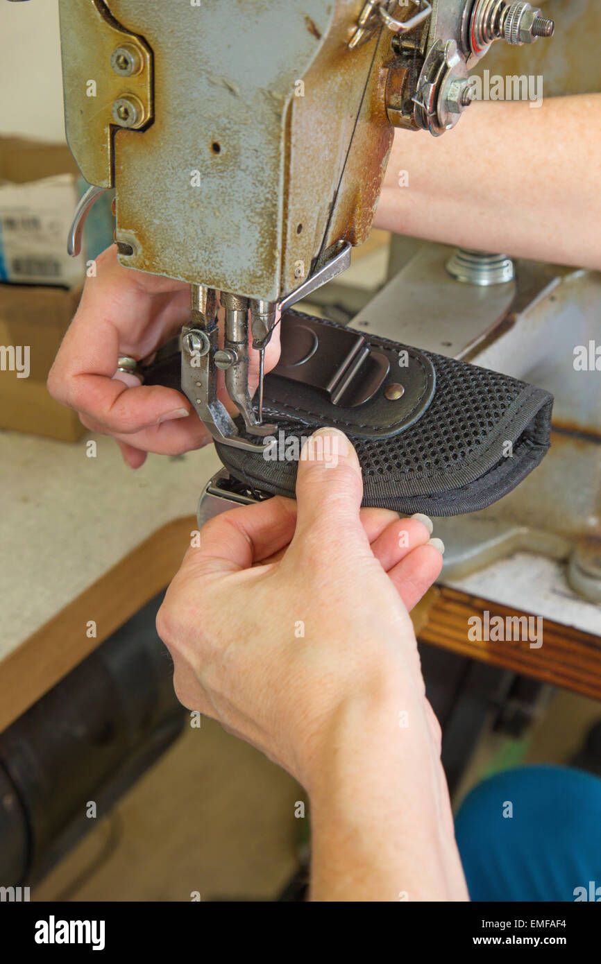 hands of the woman at the needlework of the colt case Stock Photo
