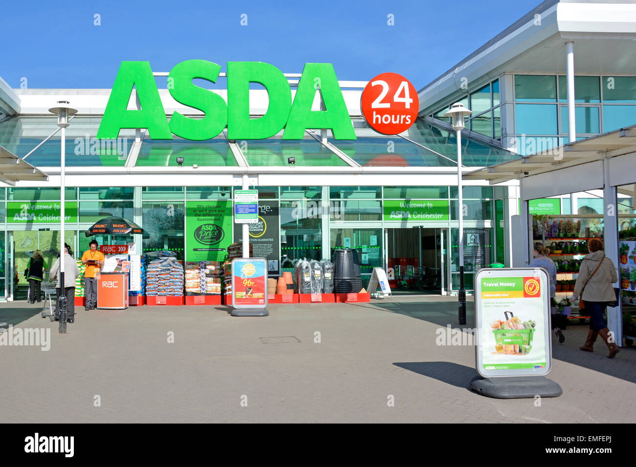 Shoppers at main entrance to Asda food & George clothing supermarket shopping retail store business with 24 hours sign Colchester Essex England UK Stock Photo