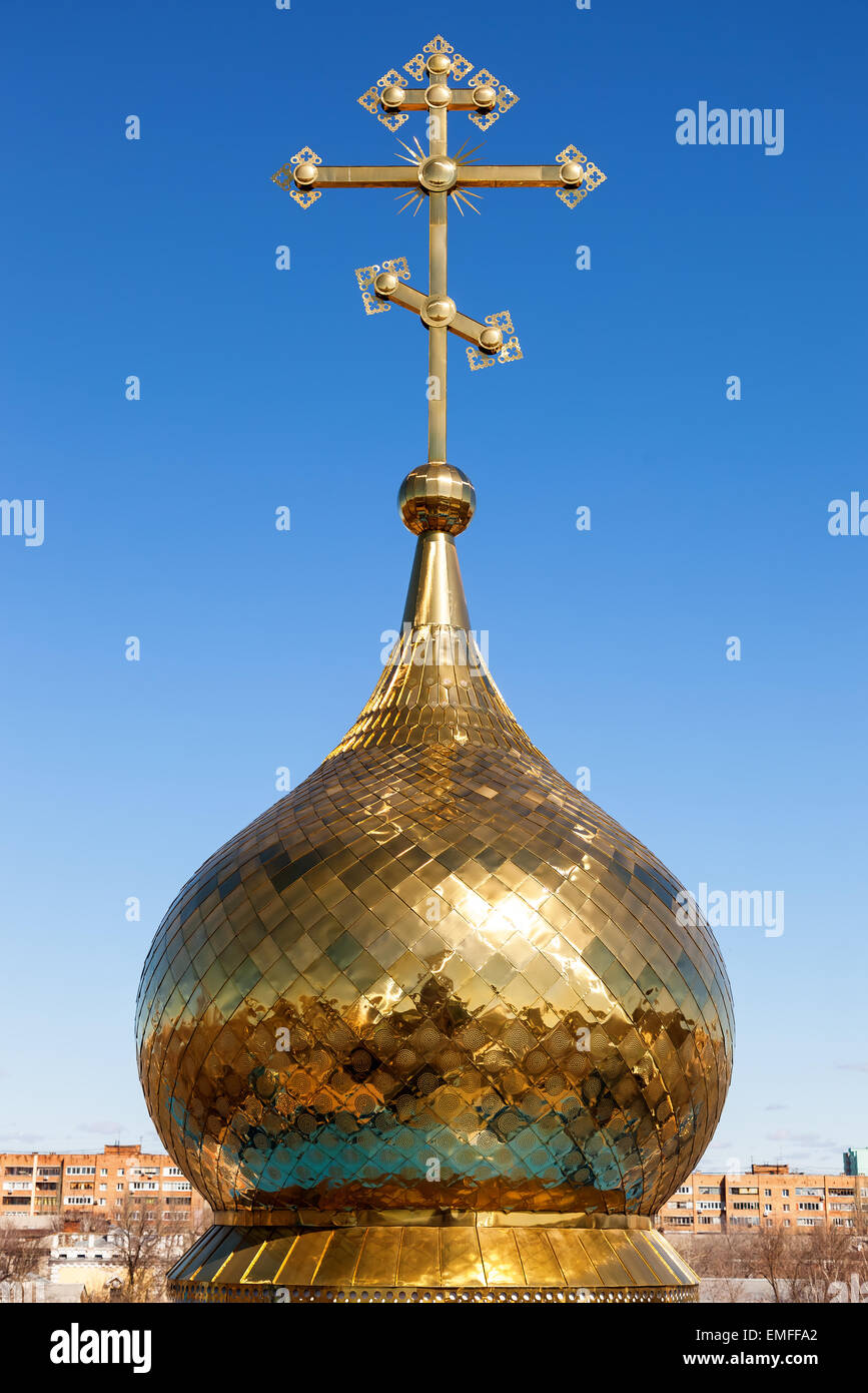Golden dome of Russian orthodox church with cross against blue sky ...