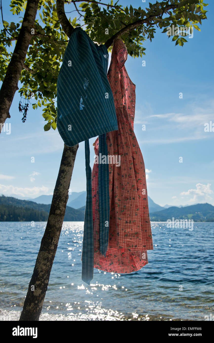 pink Dirndl hanging from a tree at lakeside, Altaussee, Styria, Austria Stock Photo