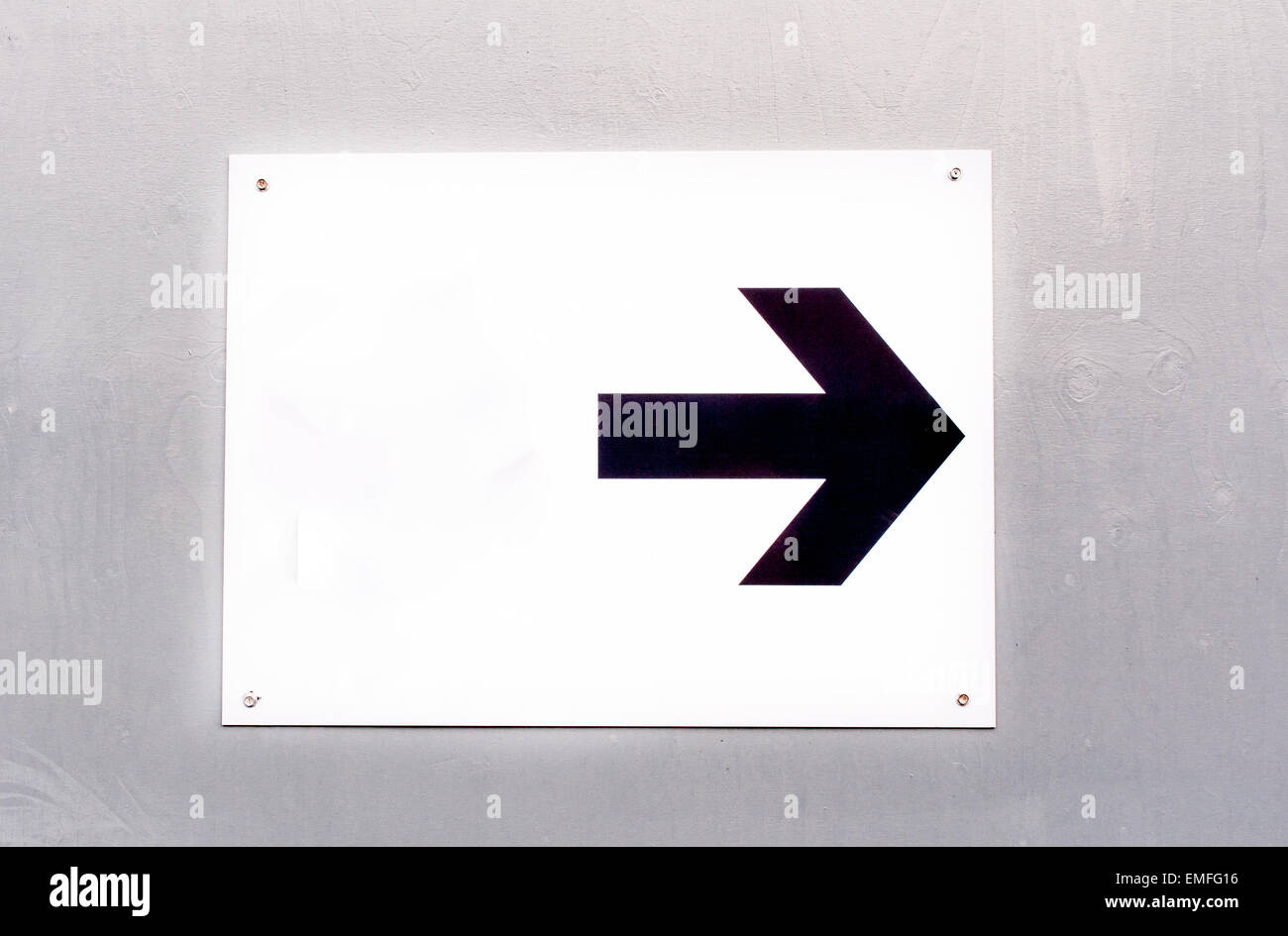 Direction arrow on white background mounted on wooden wall Stock Photo