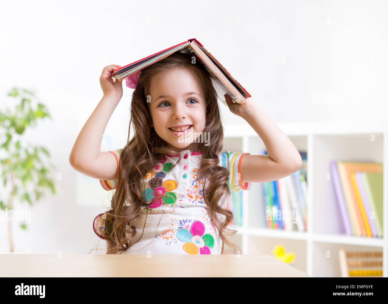 preschooler kid girl with book over her head Stock Photo - Alamy
