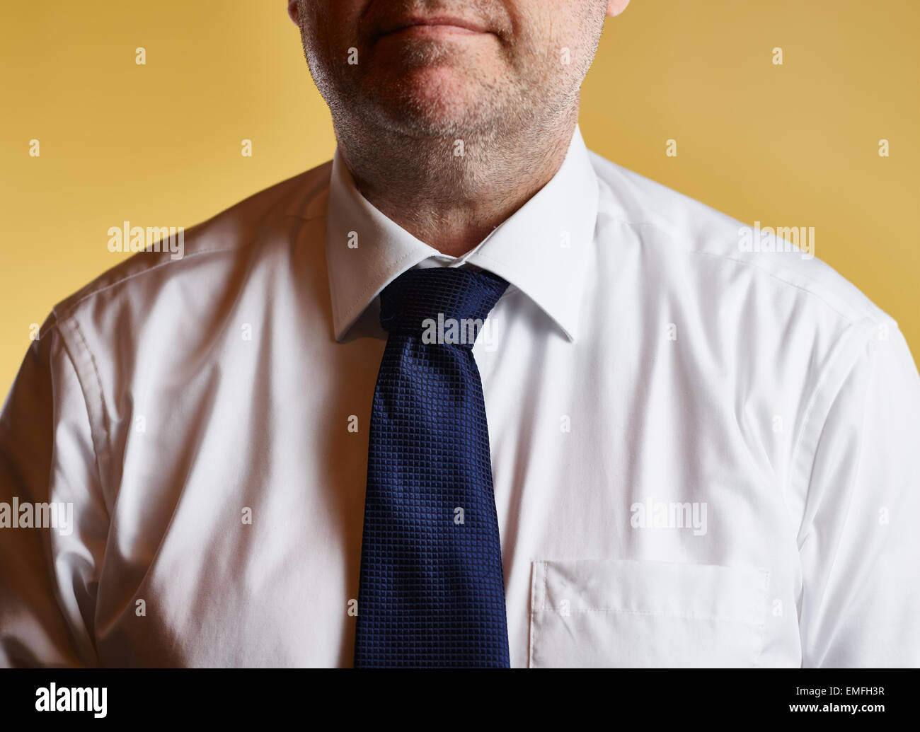 Close up, male wearing white shirt and blue tie, yellow background Stock Photo
