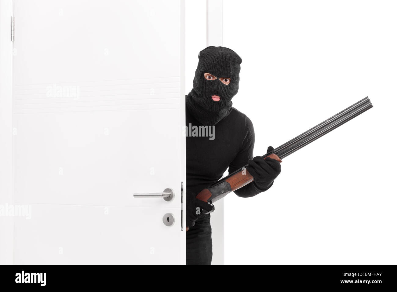 Masked terrorist entering a room and holding a shotgun rifle isolated on white background Stock Photo