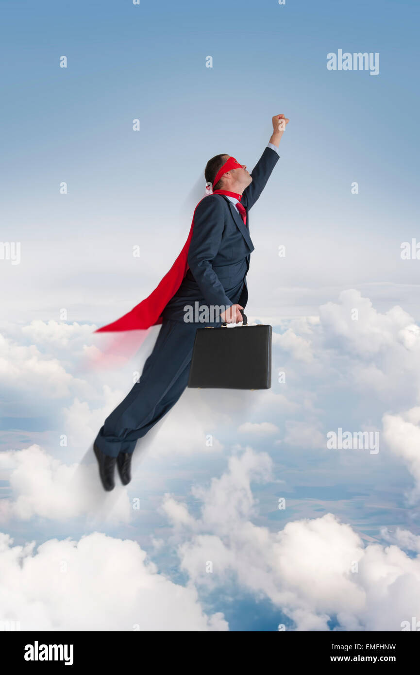 superhero businessman flying upwards in the sky Stock Photo