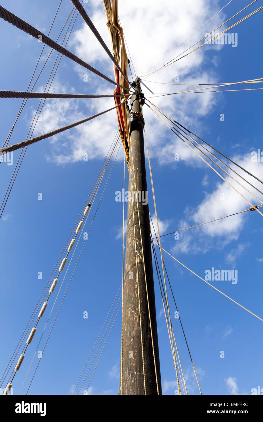 View up a mast of an old sailing boat against slightly cloudy sky Stock Photo