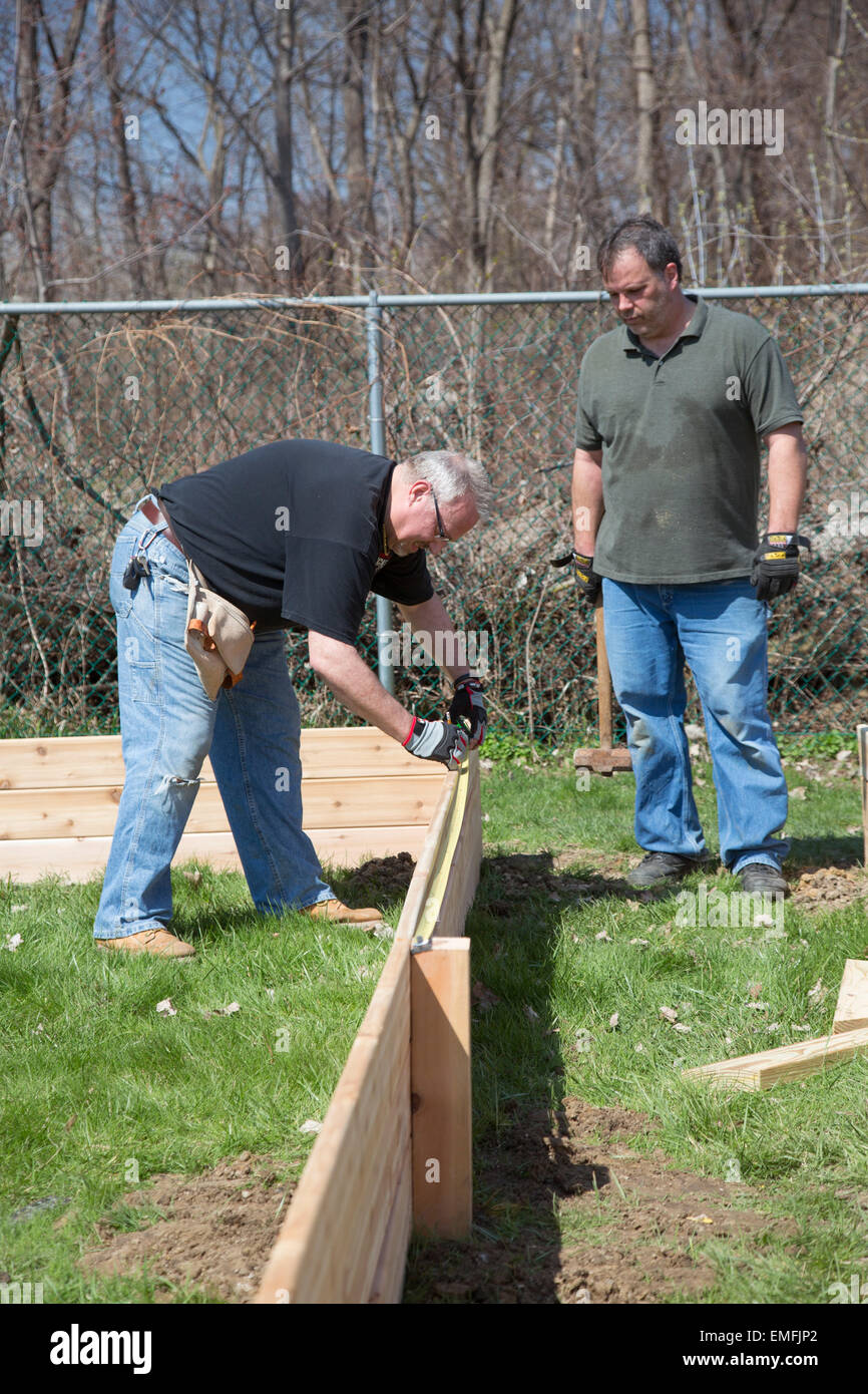 Rockford, Michigan - Volunteers build raised beds for a community garden on the grounds of a senior citizens housing complex. Stock Photo