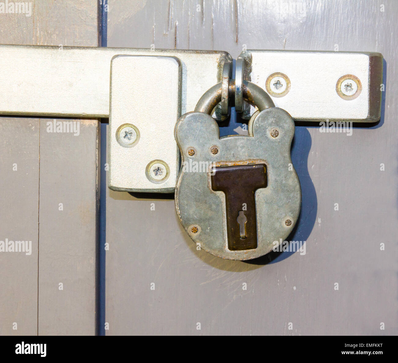 Locked padlock on grungy grey door Stock Photo