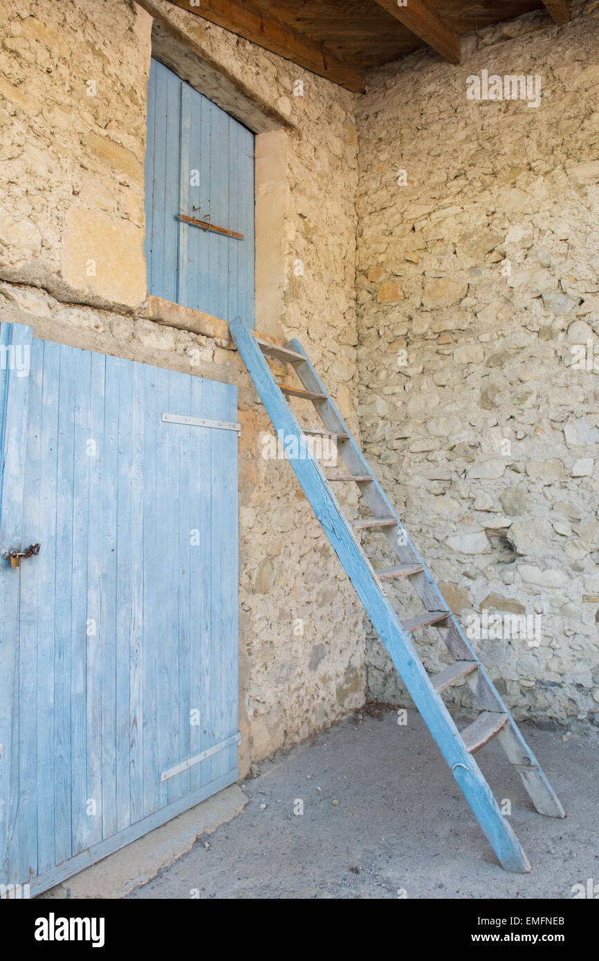 Old French barn with blue doors and stairs Stock Photo