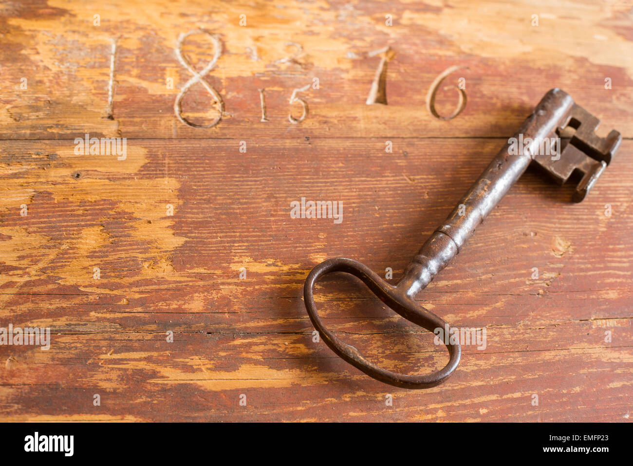 Old key on carved wooden table Stock Photo