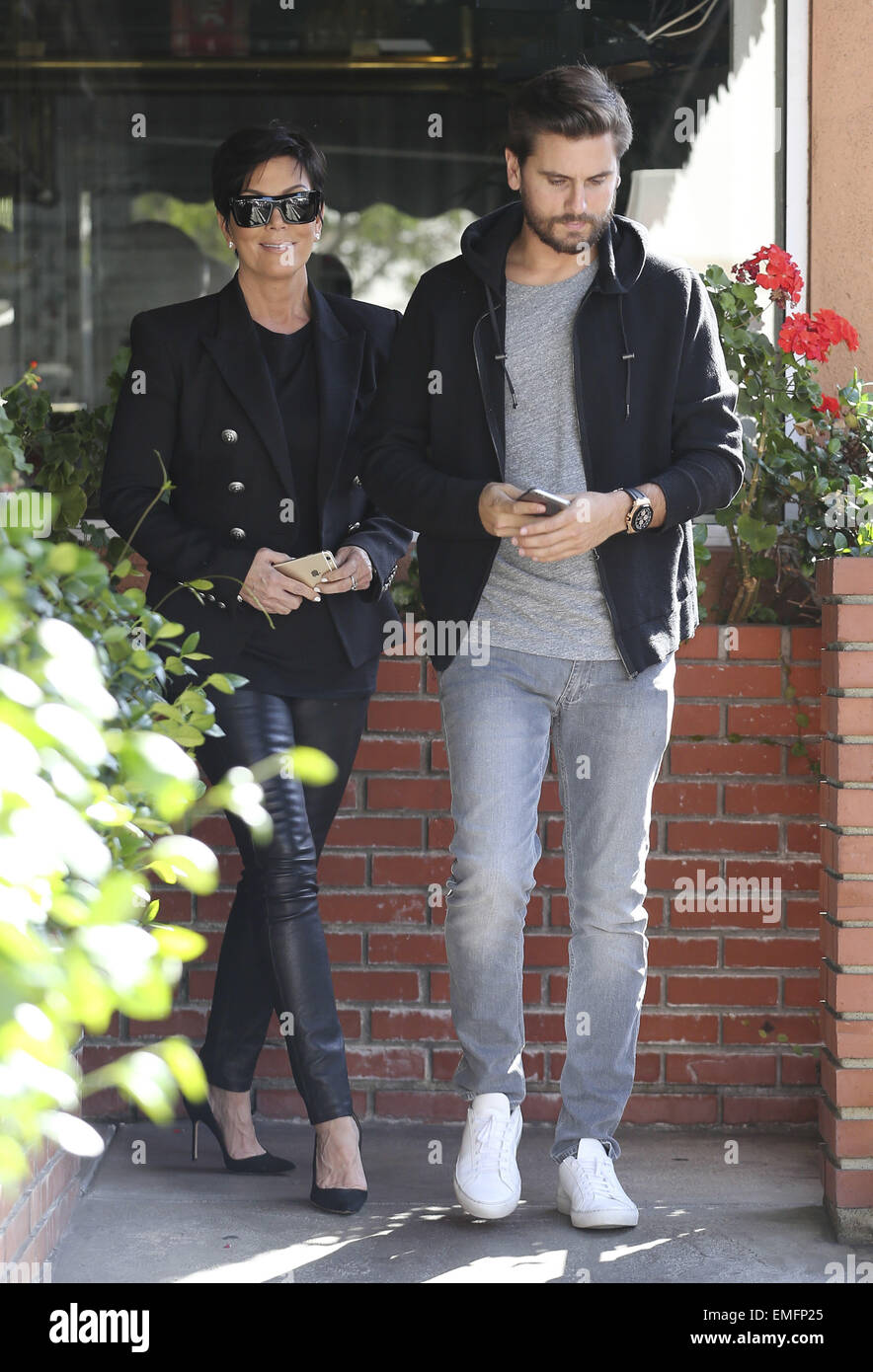 Kris Jenner and Scott Disick leave a restaurant together, both carrying