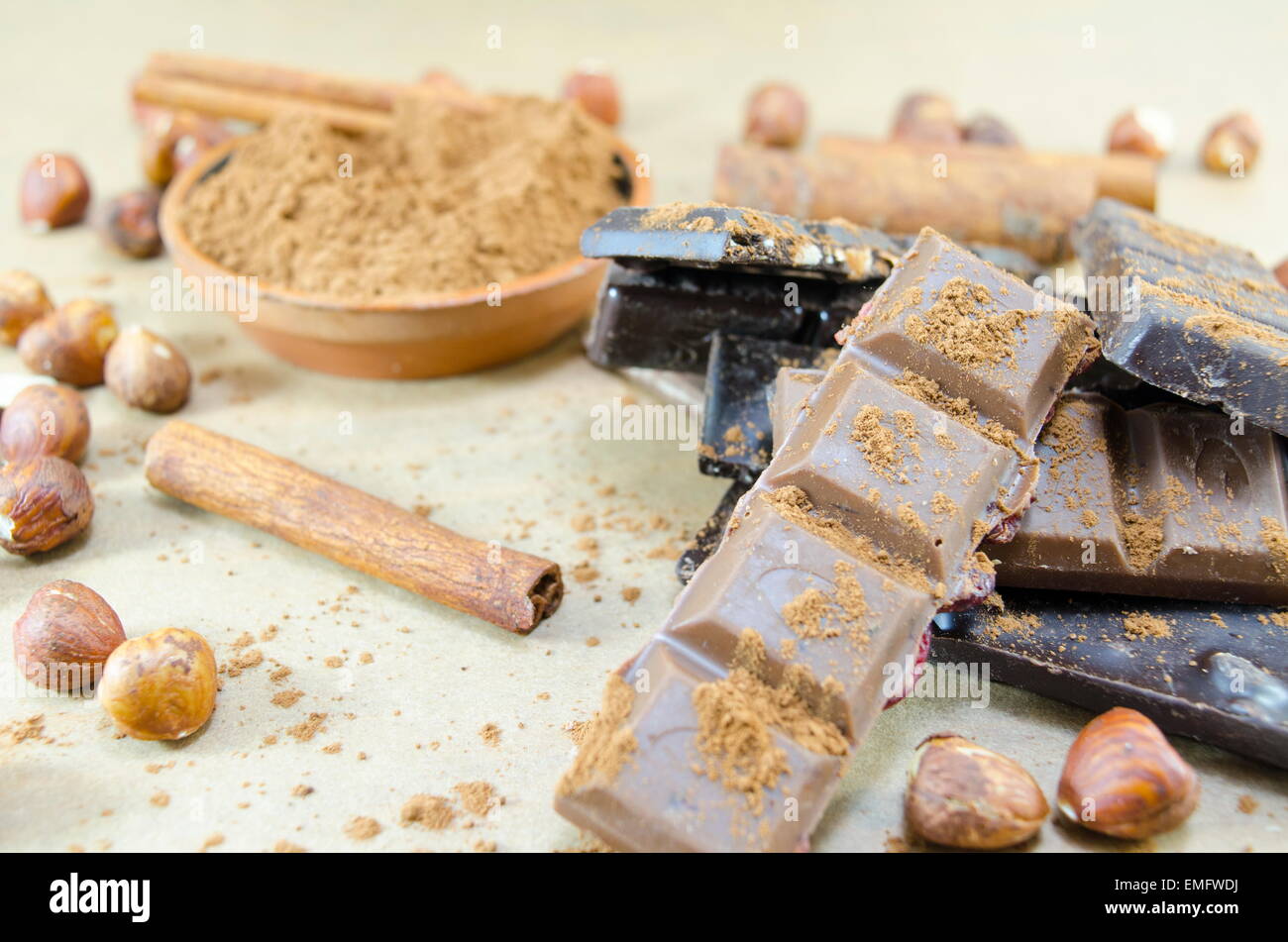 Bunch of chocolate sticks, cinnamon and hazelnuts on a table Stock Photo