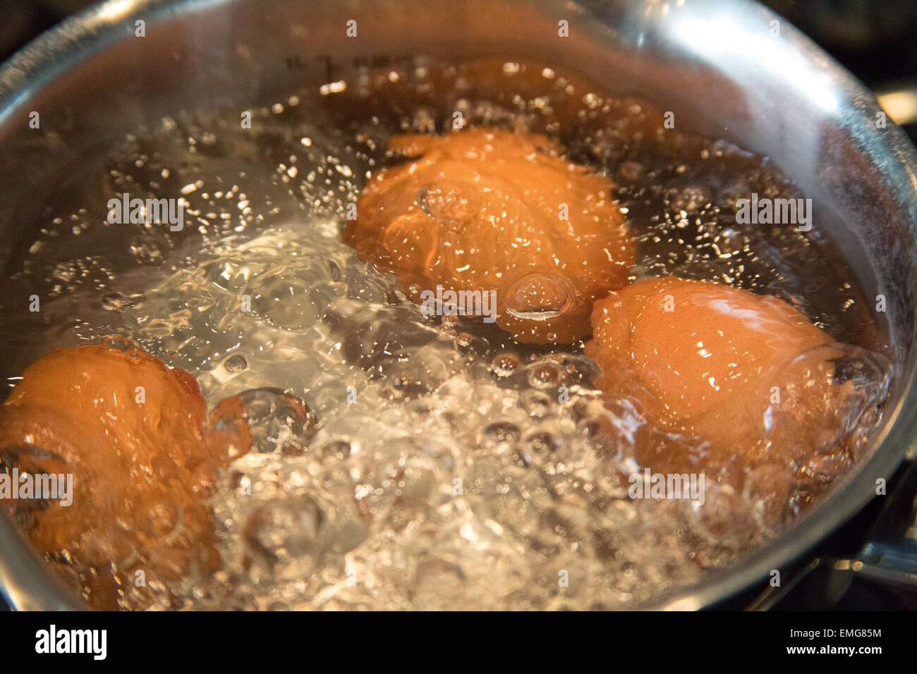 3 eggs boiling in a saucepan Stock Photo Alamy